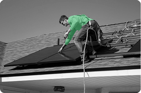 Man on top of roof installing solar panel